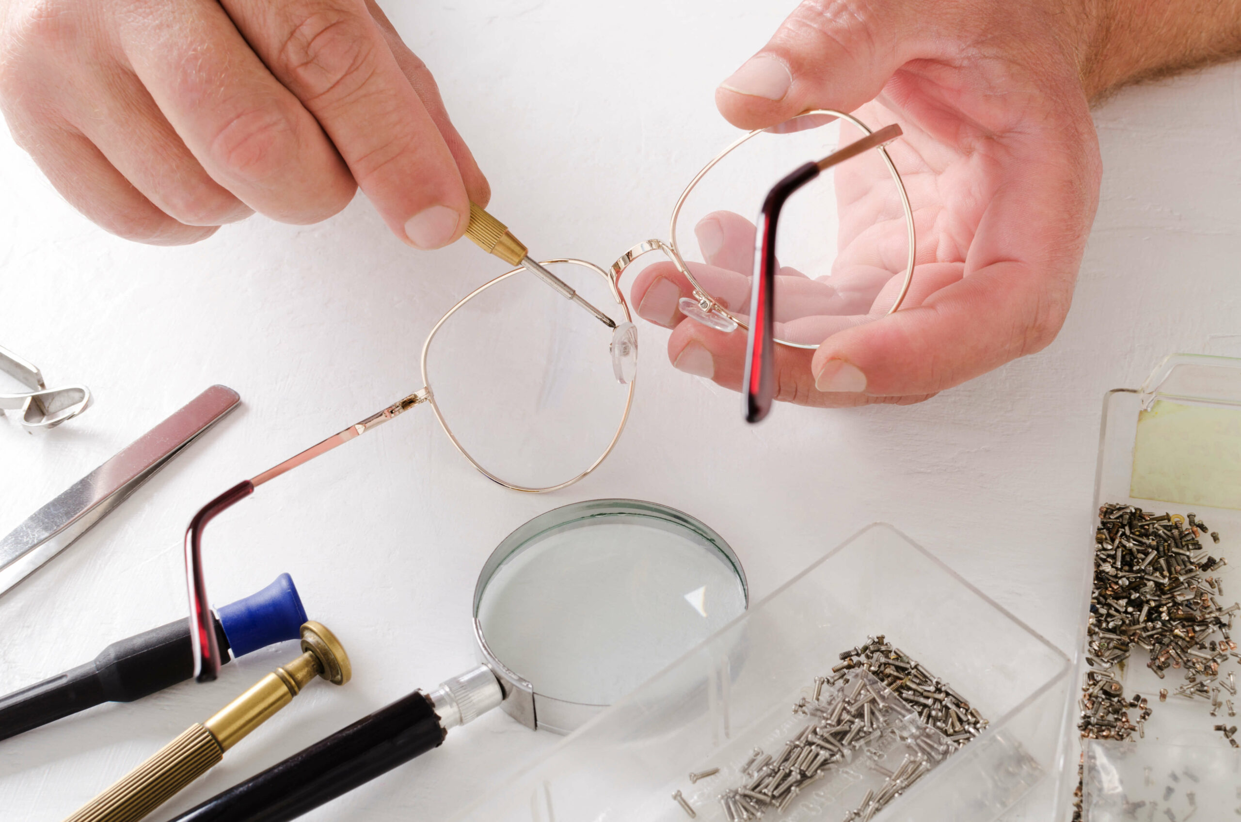 Man fixing glasses with tools